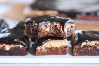 Stack of peanut butter marshmallow fudge brownies with bite taken out.