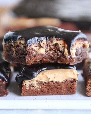 Stack of peanut butter marshmallow fudge brownies with bite taken out.