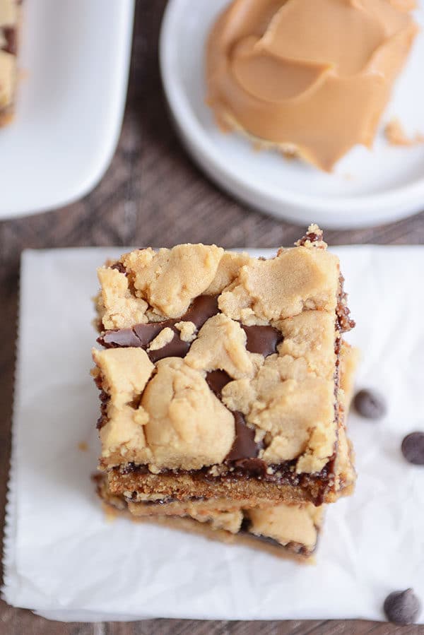 Top view of a peanut butter fudge bar stacked on top of other bars on a piece of parchment.