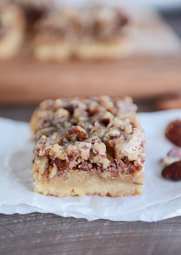 A pecan pie bar on a piece of parchment paper.
