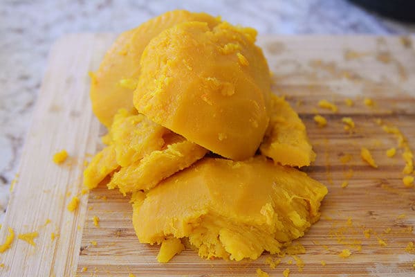 Chunks of cooked pumpkin on a cutting board.