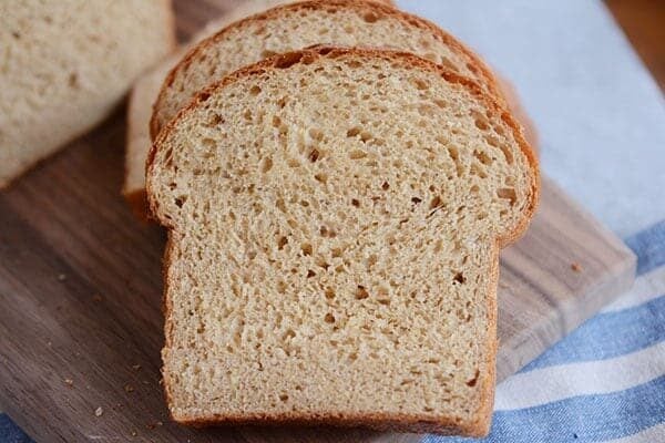 Thick slices of homemade wheat bread on a wooden cutting board.