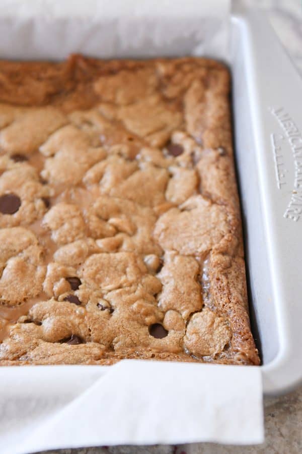 Process shot of baked salted caramel brown butter chocolate chip bars.