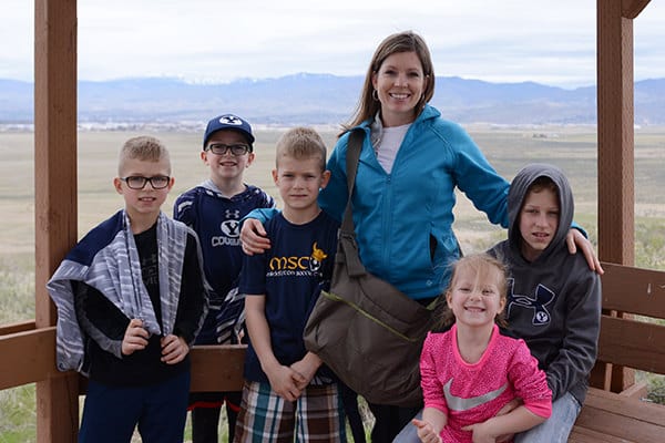 A mom standing with her five kids on a balcony. 