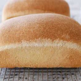 Two loaves of small batch whole wheat bread on cooling rack.