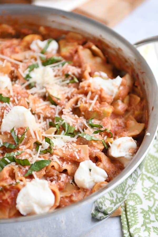 Skillet vegetable lasagna cooked in stainless skillet with dots of ricotta cheese. 