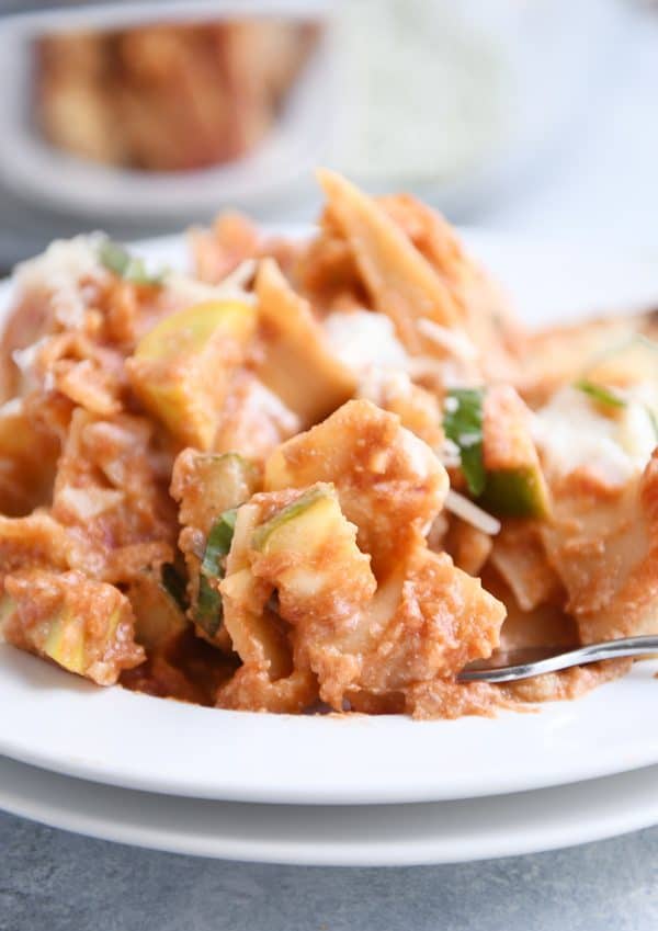Scoop of skillet vegetable lasagna on white plate. 