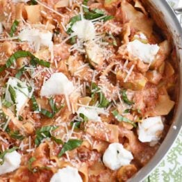 Skillet vegetable lasagna cooked in stainless skillet with dots of ricotta cheese.