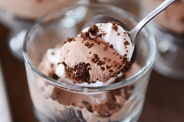 A spoon taking a bite out of a chocolate mint cheesecake dessert. 