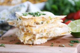 Four triangles of quesadillas stacked with cilantro on top.