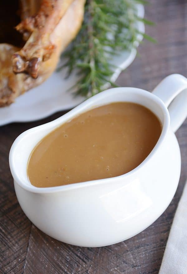 A large white gravy boat filled with brown gravy.