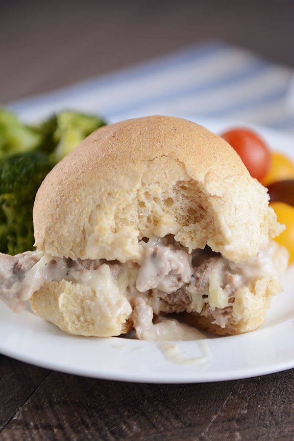 A cheesy turkey sloppy joe on a homemade bun with a bite taken out. 